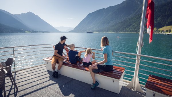 Eine Familie begibt sich auf einen Ausflug mit der Achenseeschifffahrt, um gemeinsam das Wasser und die malerische Landschaft in vollen Zügen zu genießen.